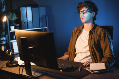 Stresli yaratıcı yönetici yeni sunumla tasarım araması yaparken ev ofisteki dizüstü bilgisayarlı ekranda gece vakti neon lambalı bir odada e-posta göndermeyi bekliyor. Toplayıcı.