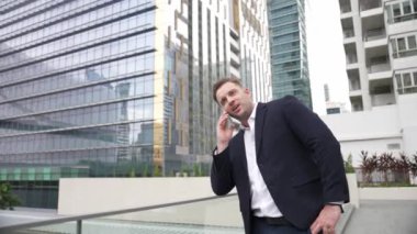 Zeki beyaz iş adamı, çatıda dururken iş arkadaşını mali strateji planlaması için arıyor. Proje yöneticisi pazarlama ekibiyle iletişim kurmak için cep telefonunu kullanıyor. Yaşam tarzı. Urbane.