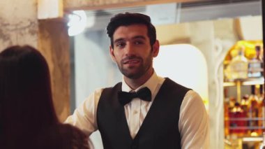 Yakışıklı, güler yüzlü bir barmen arkadaş, VIP müşterilerine içki listesi öneriyor. İçki tezgahı lüks, profesyonel barmen kostümü içinde harika bir ilk izlenim bırakıyor. Vinosity.