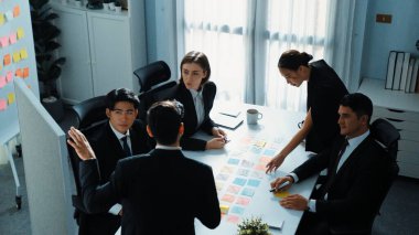 Akıllı yönetici finansal grafiğinin üst görüntüsünden çeşitli takımlara geçerken, bir grup çok kültürlü iş adamı toplantıda hisse yatırım grafiği kullanarak pazarlama stratejisi planlıyorlar. Müdürlük.