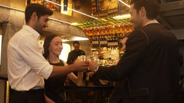 Arkadaş grubu ya da çift kadeh kaldırırken Paloma, Margarita, Eski moda ve Martini bardağında barmen arka planındaki özel partiyi kutluyorlar. Vinosity.
