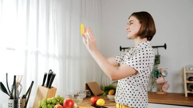 Mutlu anne sebze doğruyor ya da salata yapıp kameraya poz veriyor. Evin bekçisi kameraya bakarken taze malzemeler hazırlar. Modern mutfakta mutfak gereçleriyle yemek pişiren zeki bir anne. Pedagoji.