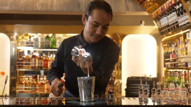 Asyalı barmenin karışık kokteyl likörünü likör karışımına katması, özel reklamı yaratıcı, canlandırıcı, bar lüksünde canlandırıcı bir vitrin haline getiriyor. Vinosity.