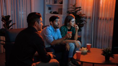 Kafkasyalı baba ve rahat anne, arkadaşlarıyla yemek yerken film izliyorlar. Babam oturma odasında abur cubur kasesi tutarken, iş arkadaşıyla televizyon seyreden mutlu bir aile. Cemaat.