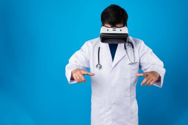 VR kulaklık takan zeki bir doktor metaevren seçerek tıbbın detaylarına yakınlaştırıyor mavi arka plan fütüristik teknoloji hologramı sanal gerçeklik zeki meta dünya. Entrika.