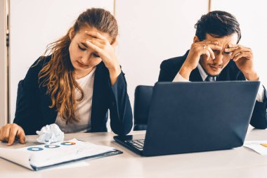Mutsuz ciddi iş adamı ve iş kadını ofis masasında dizüstü bilgisayar kullanarak çalışıyor. Kötü iş krizi ve iflas konsepti. uds