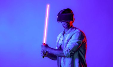 Kafkasyalı bir adam VR cam takıyor ve hareket eden el kol kılıcını tutuyor. Oyuncu, gelecekteki sanal gerçeklik kulaklığını ya da gelecekteki yenilikleri kullanarak meta dünyaya giriyor ya da aksiyon oyunu oynuyor. Sapma.
