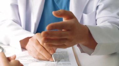 Hastanedeki doktor masasında oturup hasta test sonuçlarını teşhis eden, hastalıklar ve hastalıklar için tedavi planı geliştiren evrak işleriyle uğraşıyor. Sağlık personeli ve sağlık hizmetleri. Ağır çekim. Katı.