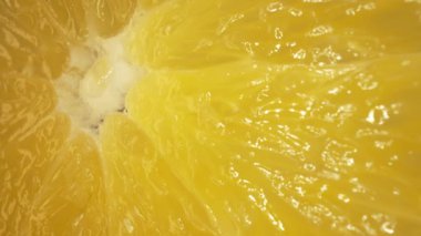 Dilimlenmiş bir portakalın canlı turuncu renginde makro fotoğrafı ve narenciye meyvesinin sulu etinden görülebilir. Portakalın eti dolgun görünüyor. Sıcaklığını gösteriyor. Geliştirilebilir.