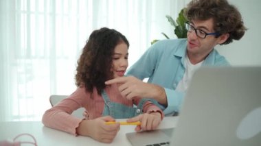 Mutlu akıllı baba, kızına mühendislik komut veya kod yazmayı öğretirken kalemini gösterip kulağına takıyor. Kafkasyalı baba programlama sistemini ya da genç liseli kızlara yapay zeka üretmeyi açıklıyor. Pedagoji.