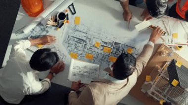 Becerikli mühendis ekibinin ev inşaatından bahsedişinin en alt görüntüsü. Mimar ya da tasarımcı grubunun planlar hakkında beyin fırtınası yapmak için tartışan ve yazan hava görüşü. Hizalama.