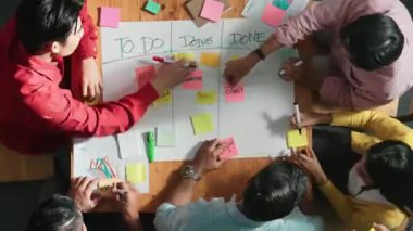 İnsanların renkli yapışkan notlarda pazarlama ve planlama stratejisi yazarken ve kargaşa yaratırken zaman aşımı görev tahtası oluşturmaları. Akıllı takım Kanaban tahtasını kullanarak iş performansını yönetir. Cemaat.