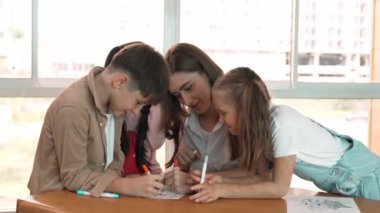 Çizim kitabında işaret kullanarak çeşitli öğrencilerin ve zeki öğretmen çizimlerinin panorama çekimi. Sanat dersinde çizim kitabını kullanarak çok kültürlü bir öğrenci. Rahatlama. Etkinlik.