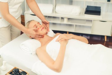 Kafkasyalı kadın stres önleyici kafa masajından ve lüks tatil beldesi ya da otel spa salonundaki modern ışık ortamında yüz güzelliği eğlencelerini şımartmaktan hoşlanıyor. Sessiz.