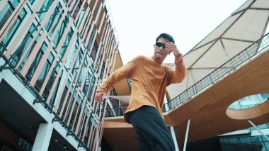 İspanyol dansçı hip hop tarzında dans ederken kameraya bakıyor. Genç ve çekici bir hippi müzik eşliğinde dans ediyor. Break dansçının hareket çekimi B-boy dansını gerçekleştirmek Açık hava sporu 2024. Hiphop.