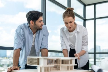 Akıllı beyaz mimar mühendis takımı ev modelini ölçmek için birlikte çalışıyor. Bir grup profesyonel iç mimar tasarım inşaatı hakkında fikir paylaşımı ve beyin fırtınası yapıyor. İzleme.