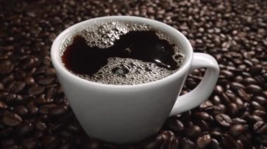 Kahve çekirdeğini yaklaştır ve kahve çekirdeği yığınıyla birlikte sıcak espresso 'ya bırak. Makro taze kavrulmuş fasulye aromatik dumanla bardağa düşüyor. Ağır çekim. Organik kahve tohumu kavramı. Geliştirilebilir.