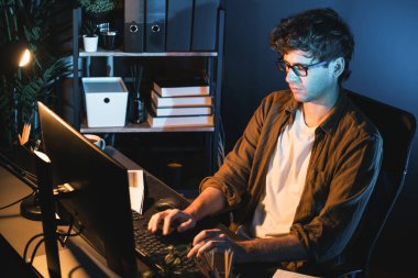 Genç işadamı, Neon Light Modern Ofis 'te yaratıcı bir başlangıç projesi için bilgisayara odaklanıyor. Düşünüyorum da, pazarlama ağı yaratıcıdan pazar kanalı tasarım konseptine çevrimiçi planlama. Toplayıcı.