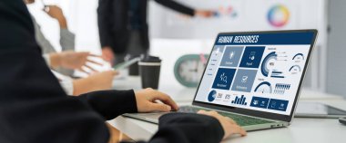 Human resources management software on computer screen helping human resources employee to manage recruitment, payroll, staff searching and KPI evaluation snugly