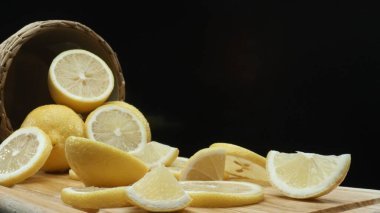 Close up of lemon slices are meticulously arranged against a rustic basket backdrop on a deep black surface. Each slice, bathed in soft light against the dark background, Macrography. Comestible. clipart