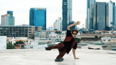 Profesyonel Asyalı break dansçı B çocuk dansı yaparken çatıda çok kültürlü arkadaşlar var. Genç modern dans grubu hip hop hareketi yapıyor. Tarz, moda, aksiyon. Açık hava sporu 2024. Hiphop.