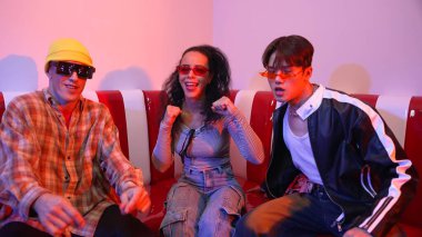 Mutlu kız kameraya bakıyor ve kanepede otururken pop müzik dinliyor. İspanyol kadın serbest stil dans ederken kameraya bakıyor neon ışıkta çeşitli arkadaşlarla dans ediyor. Mutluluk.