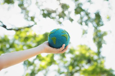 Dünya gezegenini ESG ilkesi ve çevre dostu enerjisiyle daha parlak bir gelecek için Dünya günü olarak el ele tutuşan genç çocuklar. Döngü