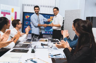 Analist ekip lideri, iş zekası ya da BI gösterge paneli ile FIntech yazılım gücünü kullanarak başarılı veri analizi toplantısından sonra iş arkadaşıyla tokalaştı. Tedbirli