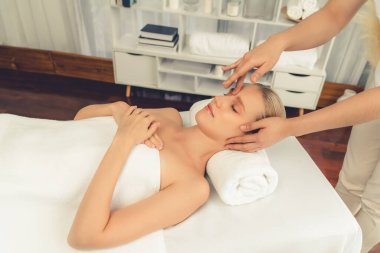 Kafkasyalı kadın stres önleyici kafa masajından ve lüks tatil beldesi ya da otel spa salonundaki modern ışık ortamında yüz güzelliği eğlencelerini şımartmaktan hoşlanıyor. Sessiz.