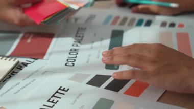 Grafik tasarımı için renk seçimi yapan ve beyin fırtınası yapan iki tasarımcının yavaş çekim çekimi ya da tasarım bürosunda kromatik danışmanlık hizmeti isteyen bir müşteri. Değiştirilmiş