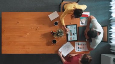 Renk paletinden renk seçmek için birlikte çalışan iş adamlarının üst düzey hava görüşü. İşadamı logo grafiğine bakarken pazarlama ekibine tablet kullanarak yönetici fikri sundu. Sempozyum.