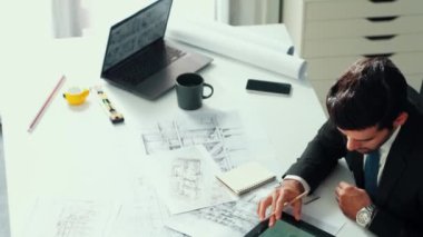 Ofiste dizüstü bilgisayar tasarımı kullanan mimar mühendisi, planlama ve ekipman dağınıklığı ile toplantı masasında otururken. Projede çalışan yetenekli inşaat mühendisi. Hizalama.