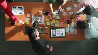 Mobil telefon arayüzü için Ux Ui tasarımı planlarken iş adamlarının yapışkan notlar üzerine yazı yazma fikrine tepeden aşağı bakış açısı. Bir grup yaratıcı tasarımcı kablo prototip tasarımı üzerinde çalışıyor. Cemaat.