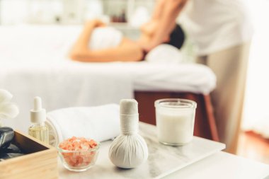 Aromaterapi masajı gündüz atmosferinde ya da spa salonunda bulanık bir kadına odak dekor ve spa aksesuarları kurarak tatil köyünde ya da otel arka planında keyifli aroma spa masajı yapan bir masaj. Sessiz.