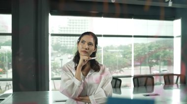 Güzel bayan lider cam tahtanın önünde projeye başlamayı düşünüyor. Gülümseyen genç proje yöneticisi yaratıcılık pazarlama stratejisini gösteren renkli yapışkan notlara bakıyor. Yönlendirici.