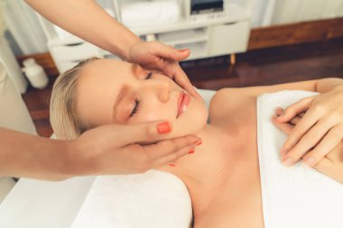 Kafkasyalı kadın stres önleyici kafa masajından ve lüks tatil beldesi ya da otel spa salonundaki modern ışık ortamında yüz güzelliği eğlencelerini şımartmaktan hoşlanıyor. Sessiz.