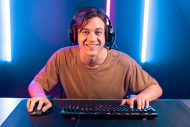 Kazanmak için çevrimiçi oyun oynayan akıllı flama makinesinin sunucu kanalı, neon ışıklı odada seçilen takım yarışması için izleyicilerle birlikte canlı yayında canlı yayında kulaklık takıyor. Bireysel.