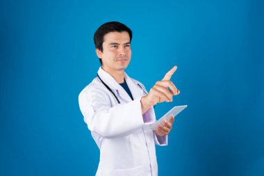 Akıllı doktor, elinde şeffaf tablet, hastalık araştırması verileri tutarak fütüristik teknolojiyle sağlık hizmetleri yenilik arayüzü hologram monitörü ekranını işaret ediyor. Entrika.