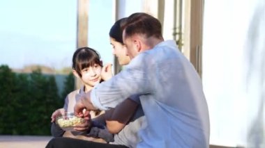 Güzel bir evlilik çifti ve kızı açık terasta piknik yapıyor. Açık hava aktivitelerini kullanan aile, çocuk için iyi bir büyüme, güçlü bir aile bağı ya da ilişkiyi güçlendirmek için sevgi ve özen göstermektedir. Uyumsuzluk.