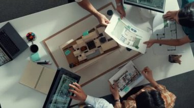 Yöneticinin ev modelini göstermesi ve bina tasarımını açıklaması. Tablet ev planı sergilenirken iç yapı hakkında beyin fırtınası yapan mimar mühendisinin hava görüntüsü. Hizalama.