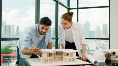 Kooperatif mimar mühendis ekibi kalem kullanarak ev modelini ölçmek için birlikte çalışıyor. Başarılı bir Kafkas iç mimari tasarım ekibi mimari model yapısını inceliyor. Tasarım. İzleme