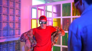 Kafkas dansçısı dans ederken çeşitli arkadaşları gece kulübünde neon ışıkta ayak seslerine bakıyor. Çoklu etnik kökenli hipsterin serbest stil müziğe geçişi ve mutlu bir adamın kameraya bakışıyla. Mutluluk.