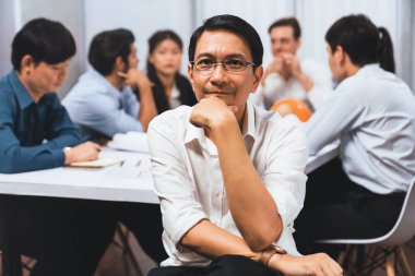 Mühendis ekip lideri portresi çeşitli inşaat mühendisi ve müvekkil gruplarıyla birlikte mimari proje üzerinde çalışıyor, inşaat planını gözden geçiriyor ve toplantı masasında proje oluşturuyorlar. Tedbirli