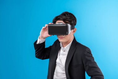 Sanal gerçeklikteki yenilik teknolojisi reklamlarını analiz ederek iş dünyası raporuna tam anlamıyla bağlanan gülümseyen Asyalı işadamı. Entrika.