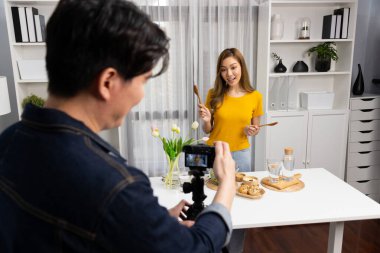 Asyalı güzel kadın yemek uzmanı blog yazarı akıllı kameramanın sosyal medya kavramında canlı yayında kaydettiği canlı yayında salatanın nasıl kolay pişirileceğini öğretiyor. İnfobahn.
