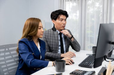 İki ekranda pazarlama raporunu analiz eden Asyalı iş arkadaşları değer borsası veritabanını modern ofisteki online raporla karşılaştırıyorlar. Değer yatırım şirketinin analizi. İnfobahn.