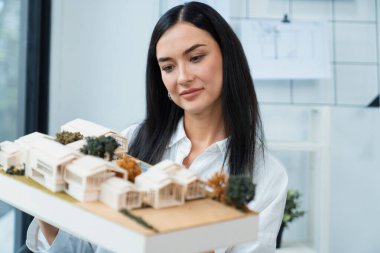 Modern ofisteki hata noktalarını incelemek ve incelemeye odaklanmak için yetenekli, genç, güzel, beyaz bir mimarın kaldırma evi modelini kapatın. Yaratıcı tasarım ve canlı konsept. Tertemiz..