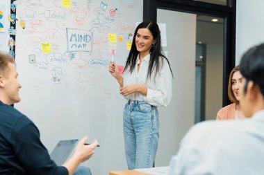 Genç ve güzel lider pazarlama stratejisini sunarken, uzman yatırımcı ve proje yöneticisi de yeni başlayan iş toplantısında iş performansını analiz etmeye çalışıyor. Çok ırklı bir grup. Tertemiz..