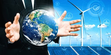 Alternatif enerji ile sürdürülebilirlik gelişimi kavramı. Çevre dostu rüzgar türbini çiftliği ve arka planda yeşil yenilenebilir enerji olan gezegenle insan eli ilgilenir. uds