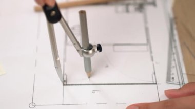 Bölücü araç ve el yazısı kullanan akıllı mimar ya da güvenlik mühendisinin videosu mimari ofisteki inşaat doğruluğu planının ayrıntılarını içeriyor. Eline odaklan. - Yakın çekim. Tanımlama.